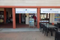 Outdoor view of Maby Mare excursion and boat rental office with signage and seating area.