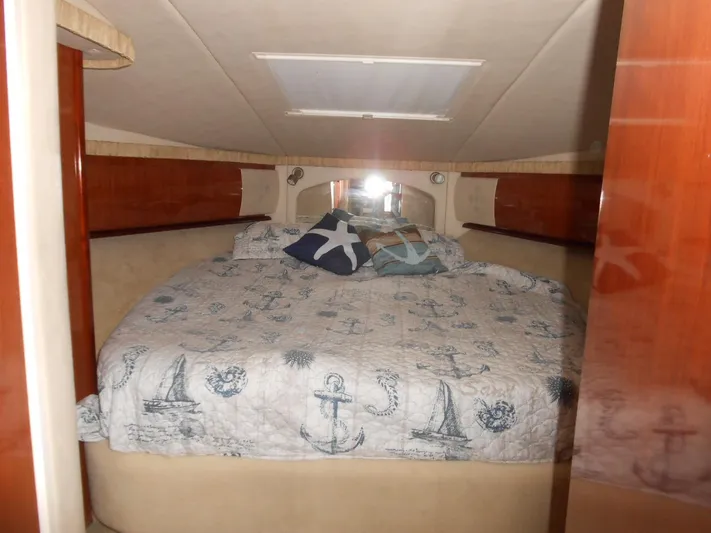  Yacht Photos Pics Interior cabin of 2004 Sea Ray 420 Sundancer with nautical-themed bedding.