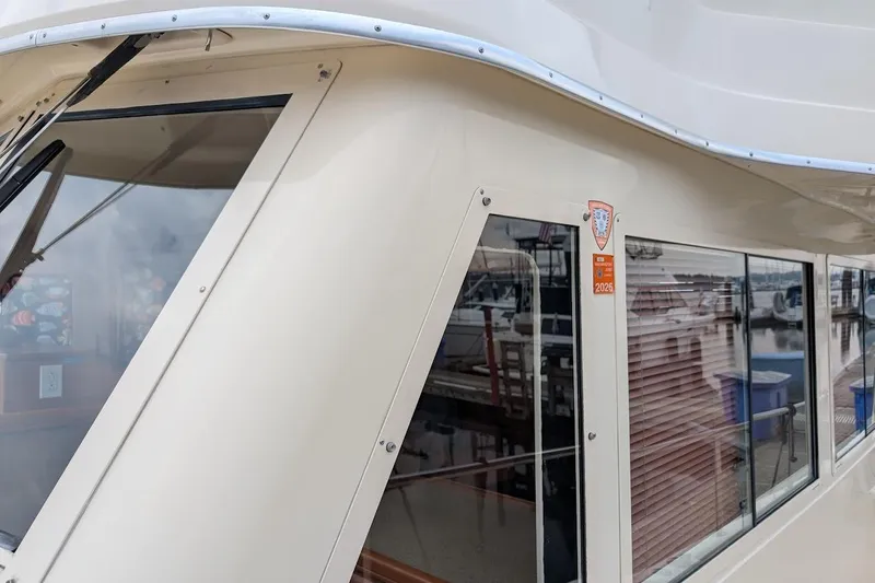 Lulu Jack Yacht Photos Pics 2008 Mainship 38 boat exterior with windows and marina reflection.