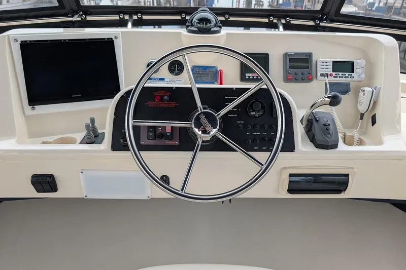 Lulu Jack Yacht Photos Pics Control panel of a 2008 Mainship 38 boat with steering wheel and navigation instruments.