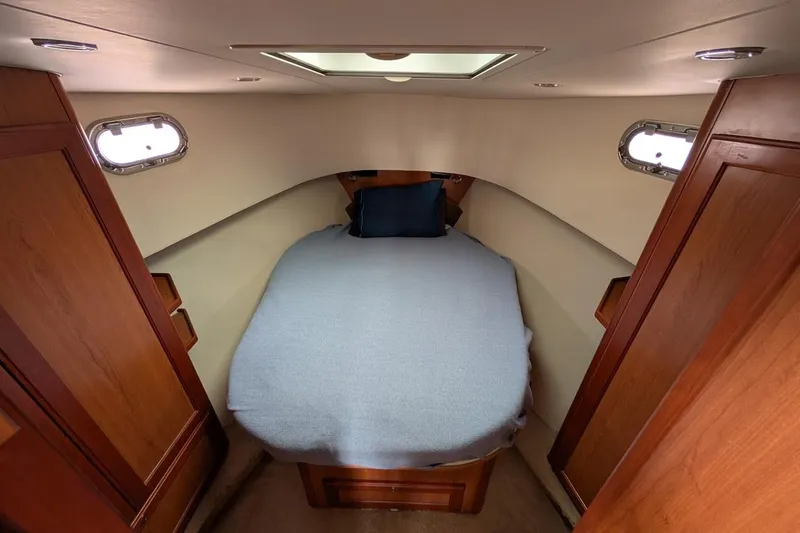 Lulu Jack Yacht Photos Pics Cozy cabin interior of 2008 Mainship 38 with bed and wooden cabinetry.