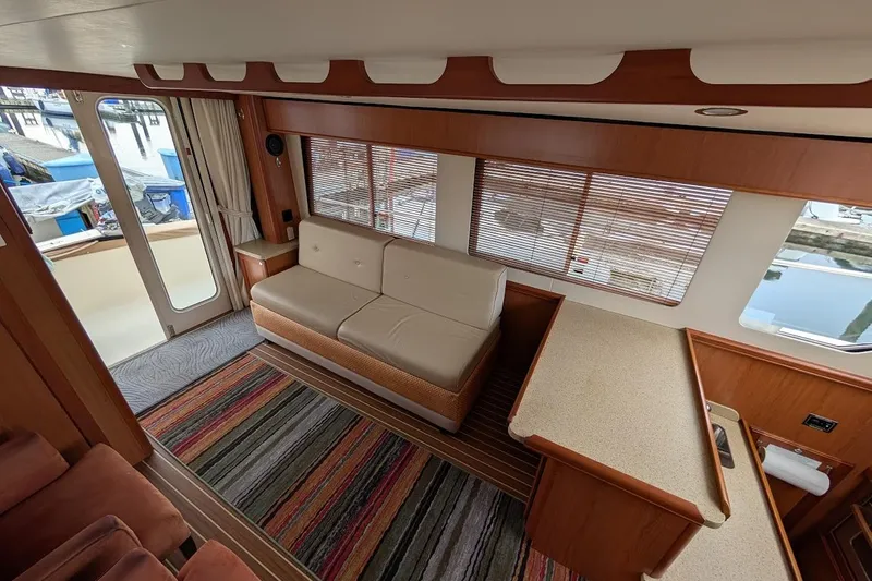 Lulu Jack Yacht Photos Pics Interior of 2008 Mainship 38 yacht with sofa, striped rug, and large windows.