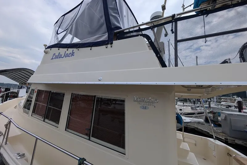 Lulu Jack Yacht Photos Pics 2008 Mainship 38 boat docked at marina, featuring upper deck enclosure.