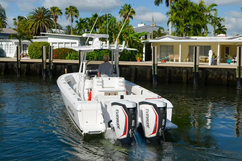 Quid Pro Quo Yacht Photos Pics 2013 Intrepid 300 Center Console boat cruising near waterfront homes.