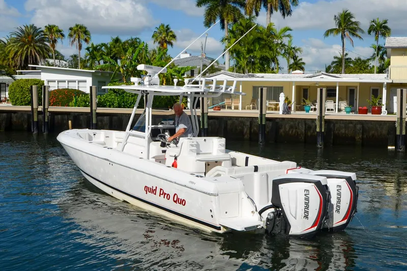 Quid Pro Quo Yacht Photos Pics 2013 Intrepid 300 Center Console boat docked near waterfront homes.