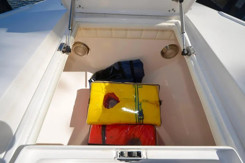 Quid Pro Quo Yacht Photos Pics Storage compartment on a 2013 Intrepid 300 Center Console with colorful bags inside.