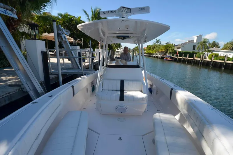 Quid Pro Quo Yacht Photos Pics 2013 Intrepid 300 Center Console boat docked by a canal with lush surroundings.