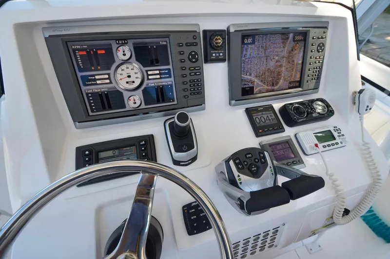 Quid Pro Quo Yacht Photos Pics Control panel of a 2013 Intrepid 300 Center Console boat with navigation and communication equipment.