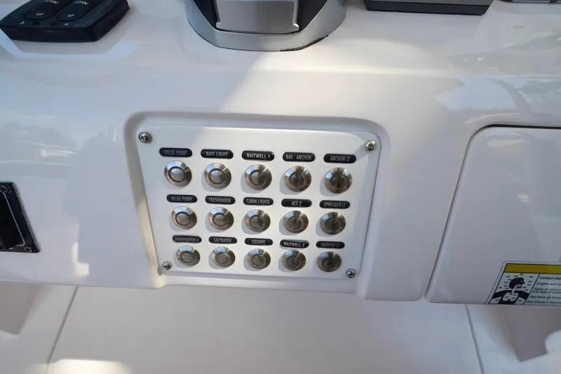 Quid Pro Quo Yacht Photos Pics Control panel of 2013 Intrepid 300 Center Console boat with labeled switches.