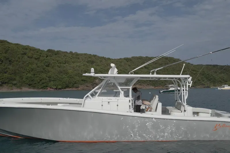 Backstage Yacht Photos Pics 2015 Yellowfin 42 Offshore boat on calm water near a lush green shoreline.