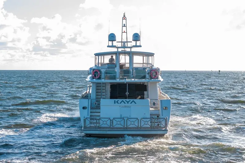 Kaya Yacht Photos Pics 2003 Johnson 87' Motor Yacht cruising on open sea under a bright sky.