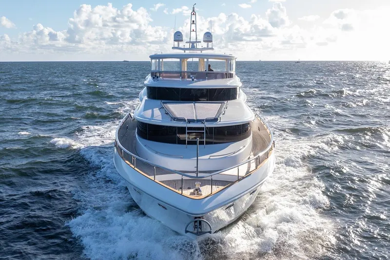 Kaya Yacht Photos Pics Luxurious 2003 Johnson 87' Motor Yacht cruising on open sea under clear skies.