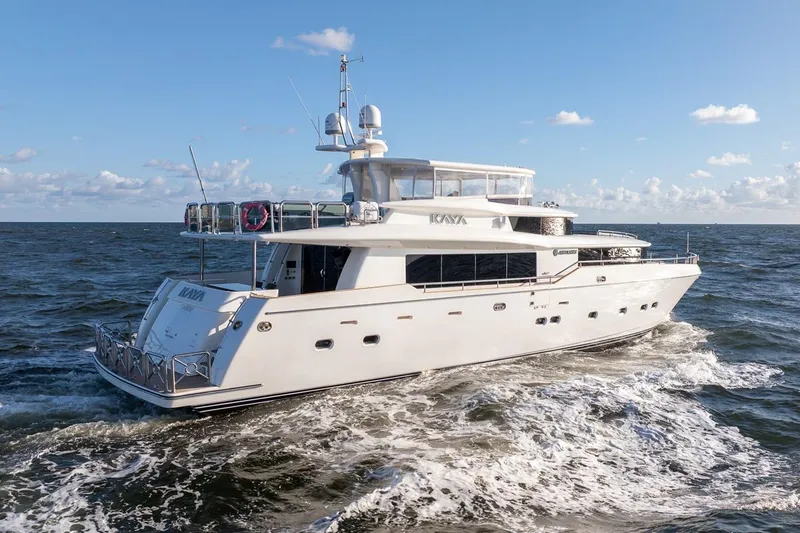 Kaya Yacht Photos Pics Luxury 2003 Johnson 87' Motor Yacht cruising on open sea under clear skies.