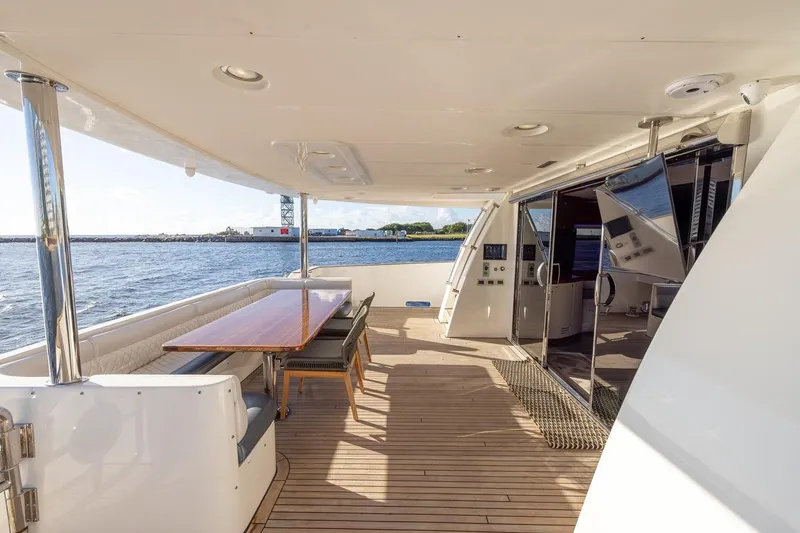 Kaya Yacht Photos Pics Luxurious 2003 Johnson 87' Motor Yacht deck with dining area and ocean view.