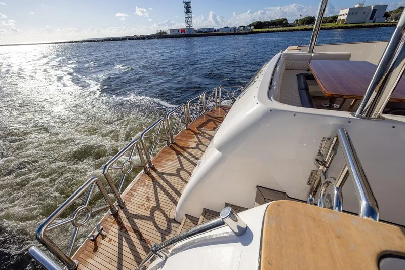 Kaya Yacht Photos Pics 2003 Johnson 87' Motor Yacht cruising on open water, featuring elegant deck design.