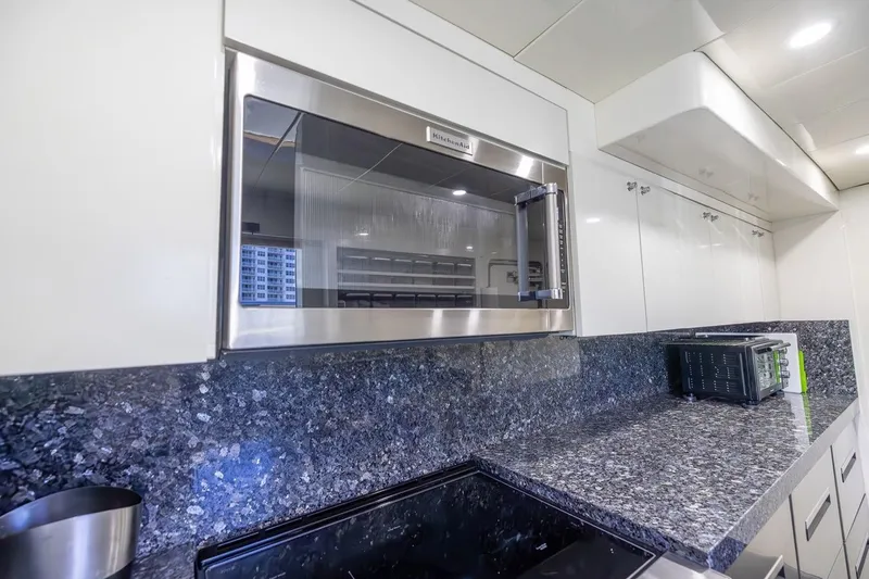 Kaya Yacht Photos Pics Modern kitchen in 2003 Johnson 87' Motor Yacht with granite countertops and stainless steel appliances.