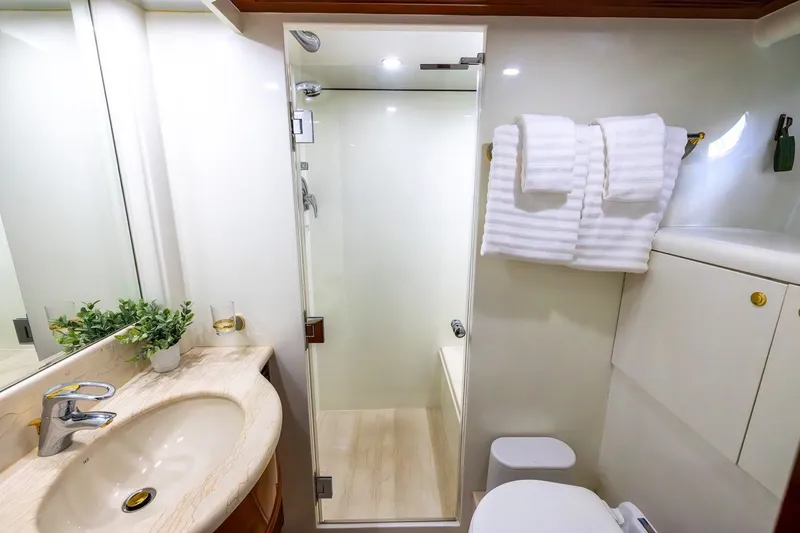 Kaya Yacht Photos Pics Luxurious bathroom in 2003 Johnson 87' Motor Yacht with modern fixtures and elegant design.