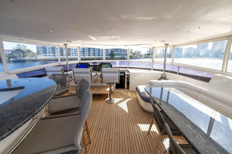 Kaya Yacht Photos Pics Luxurious interior of 2003 Johnson 87' Motor Yacht with panoramic windows and elegant seating.