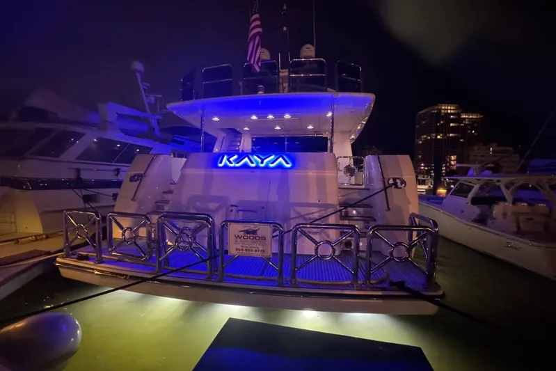 Kaya Yacht Photos Pics Luxurious 2003 Johnson 87' Motor Yacht docked at night with illuminated name "Kaya".