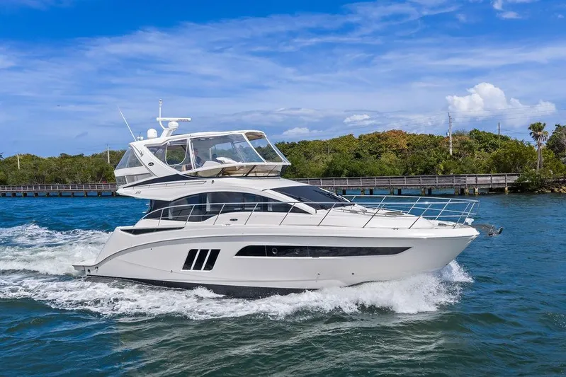 Ern'd It Yacht Photos Pics 2017 Sea Ray Fly 510 yacht cruising on blue water under a clear sky.