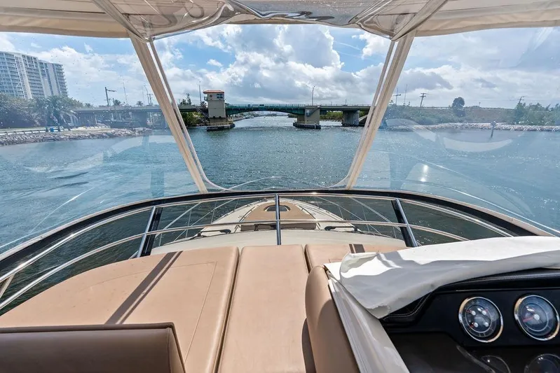 Ern'd It Yacht Photos Pics 2017 Sea Ray Fly 510 yacht cruising under a sunny sky near a bridge.