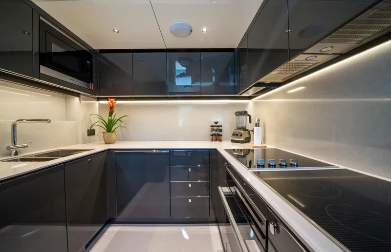  Yacht Photos Pics Modern kitchen interior on 2025 Sunseeker 100 Yacht, featuring sleek cabinetry and appliances.