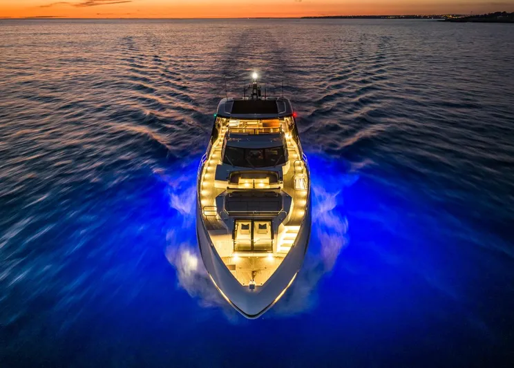  Yacht Photos Pics Sunseeker 100 Yacht 2025 cruising at sunset with vibrant blue underwater lights.