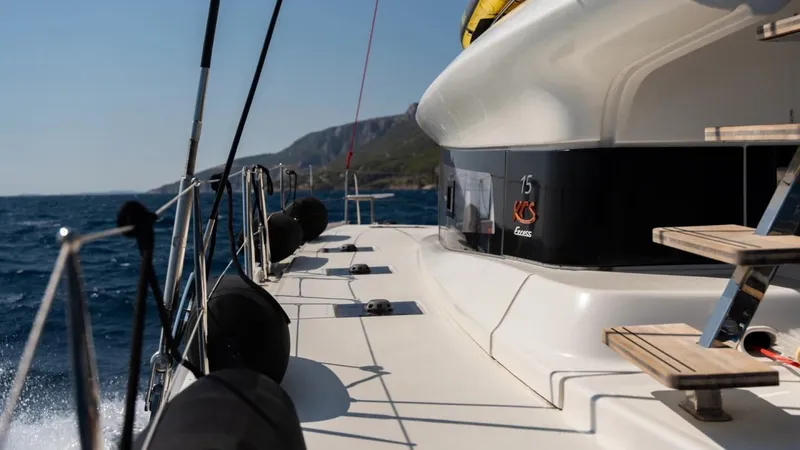  Yacht Photos Pics 2023 Excess 15 yacht sailing on open sea with coastal view.