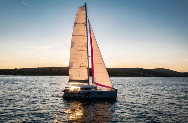  Yacht Photos Pics Sailing yacht Excess 15, 2023 model, on serene water at sunset.