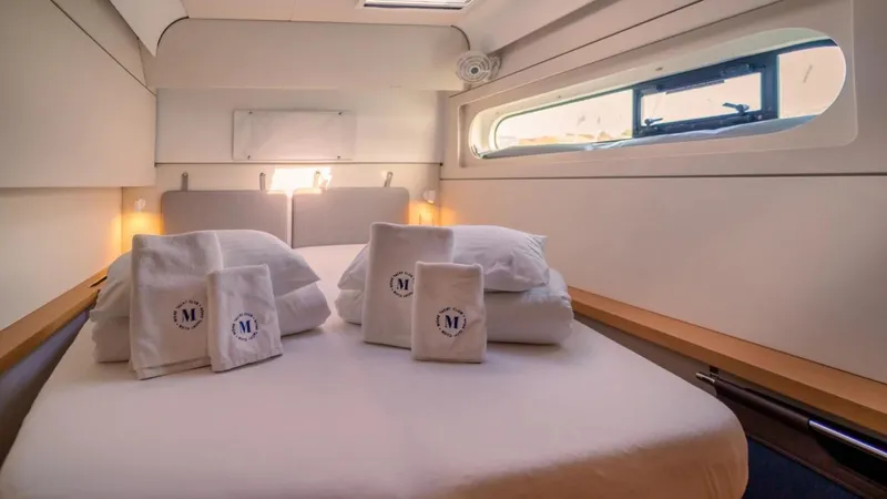  Yacht Photos Pics Luxurious cabin interior of 2023 Excess 15 yacht with neatly arranged towels and bedding.