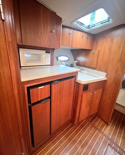 First Light II Yacht Photos Pics 1998 Tiara Yachts 3500 Open galley with wood cabinetry and compact appliances.