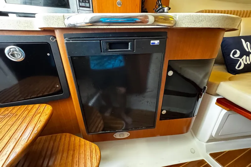  Yacht Photos Pics 2007 Hydra-Sports Vector 3300 VX interior with wooden cabinetry and compact refrigerator.