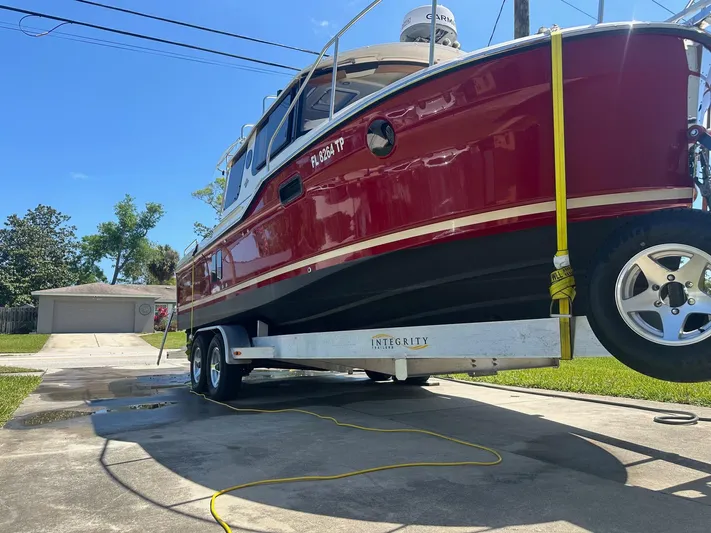  Yacht Photos Pics 2023 Ranger Tugs R-25 boat on trailer in driveway, sunny day.
