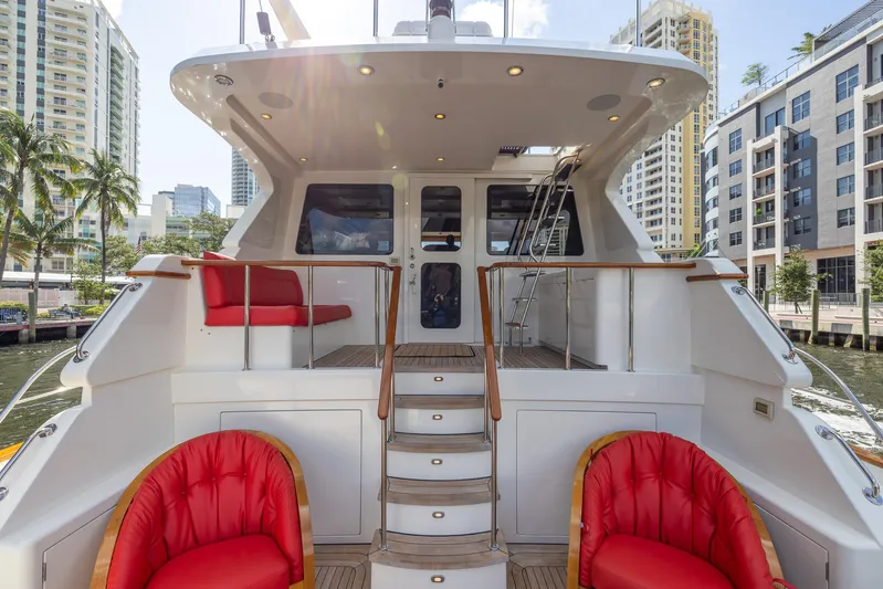 Liberty Yacht Photos Pics 2004 Lyman-Morse Motoryacht deck with red seating, cityscape background.