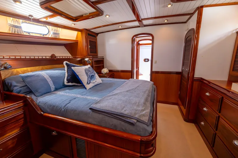 Liberty Yacht Photos Pics Luxurious 2004 Lyman-Morse Motoryacht bedroom with elegant wood finish and cozy bedding.