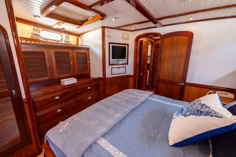 Liberty Yacht Photos Pics Luxurious 2004 Lyman-Morse Motoryacht cabin with elegant wood finishes and cozy bedding.