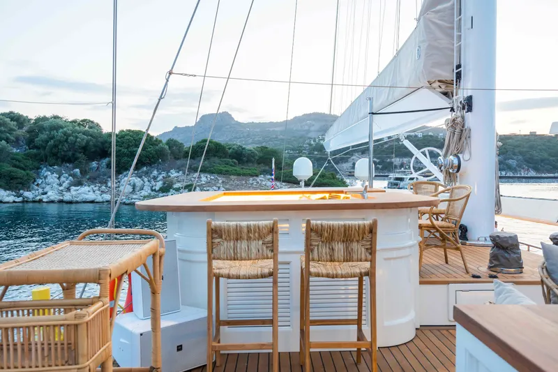 Yazz Yacht Photos Pics Luxury Aegean Yacht 2007 deck with bar and seating, scenic coastal view.