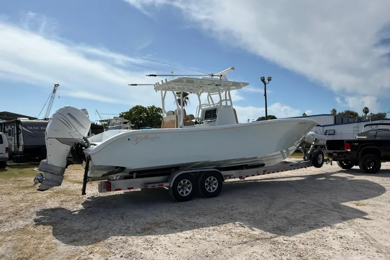  Yacht Photos Pics 2018 Yellowfin 32 Offshore boat on trailer, parked outdoors under a partly cloudy sky.