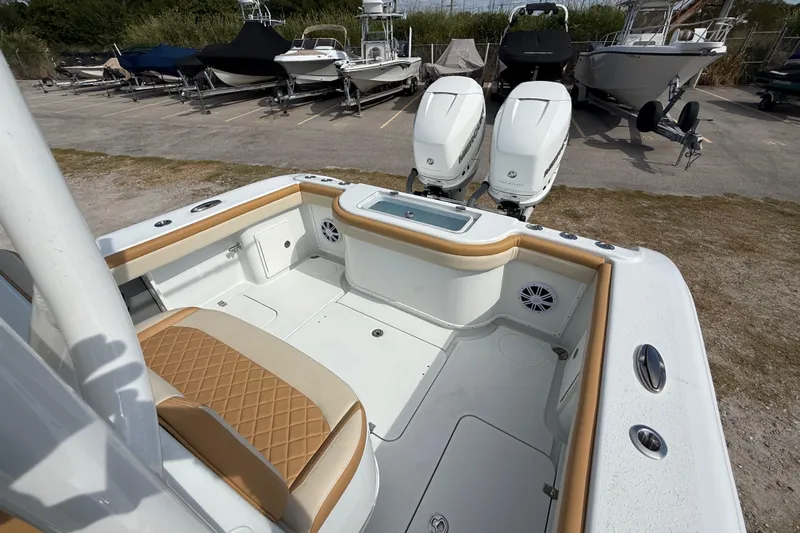  Yacht Photos Pics 2018 Yellowfin 32 Offshore boat interior with dual engines, parked among other boats.