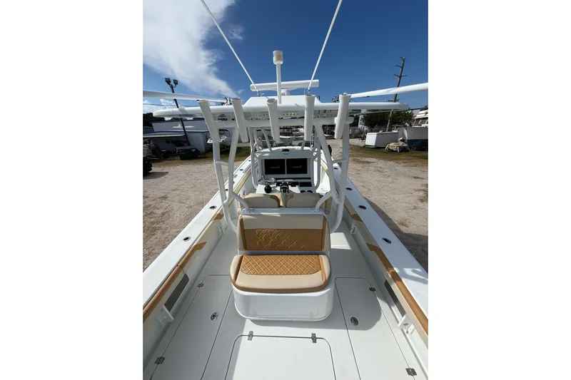  Yacht Photos Pics 2018 Yellowfin 32 Offshore boat interior with helm and seating under clear blue sky.