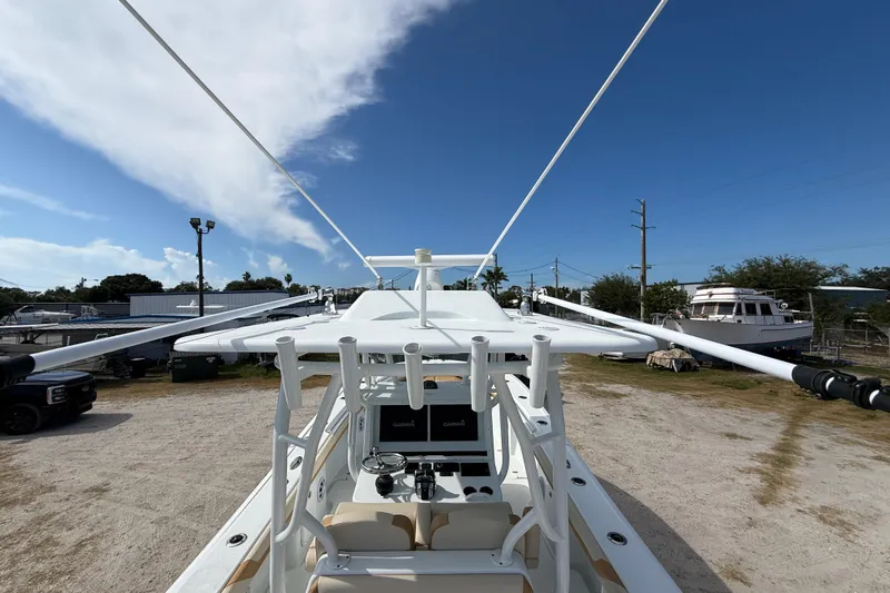  Yacht Photos Pics 2018 Yellowfin 32 Offshore boat with outriggers, parked outdoors under a clear blue sky.