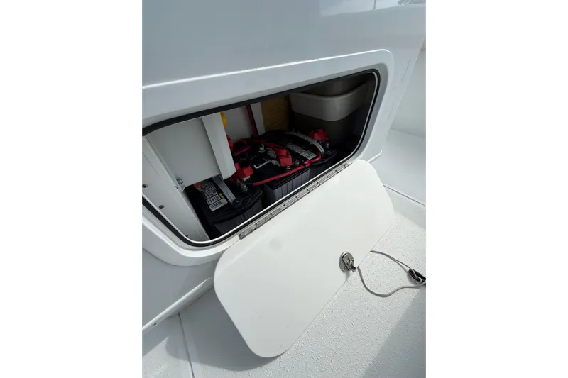  Yacht Photos Pics Open storage compartment on 2018 Yellowfin 32 Offshore boat, showing equipment and battery.