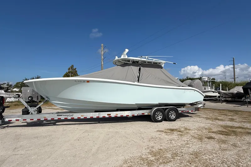  Yacht Photos Pics 2018 Yellowfin 32 Offshore boat on trailer, covered, under clear blue sky.