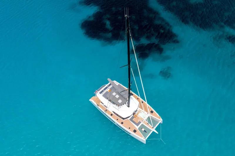 Semper Fidelis Yacht Photos Pics Aerial view of 2022 Fountaine Pajot Alegria 67 catamaran on clear blue water.