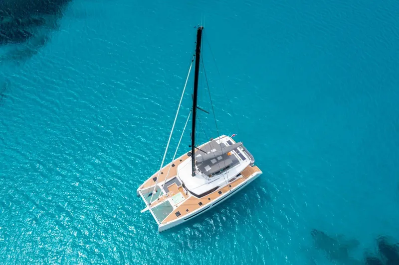 Semper Fidelis Yacht Photos Pics Aerial view of 2022 Fountaine Pajot Alegria 67 catamaran on clear blue water.
