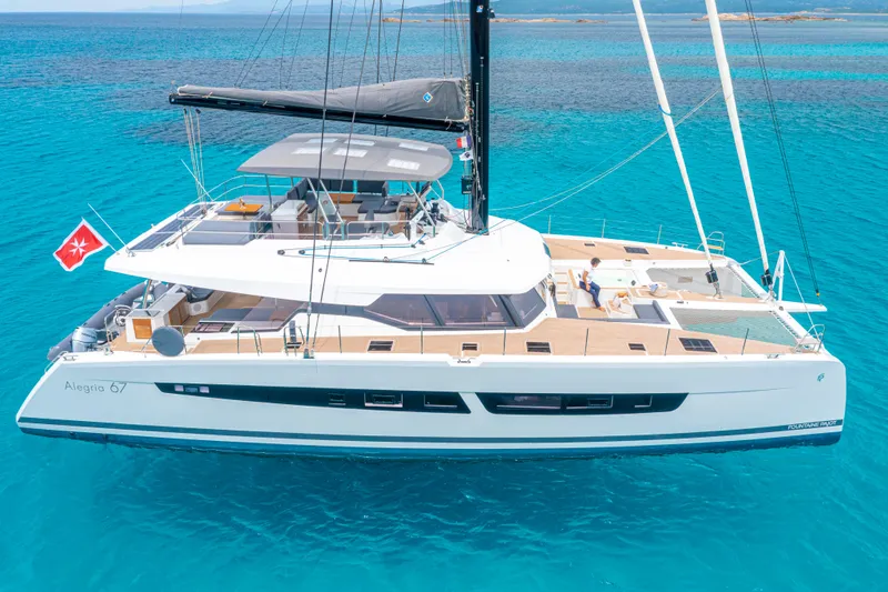 Semper Fidelis Yacht Photos Pics 2022 Fountaine Pajot Alegria 67 catamaran sailing on clear blue waters.