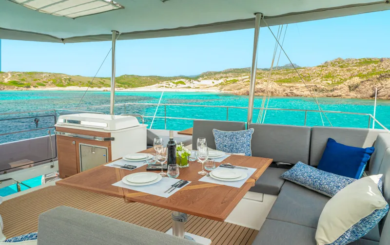Semper Fidelis Yacht Photos Pics Luxurious 2022 Fountaine Pajot Alegria 67 yacht with elegant dining area and stunning ocean view.