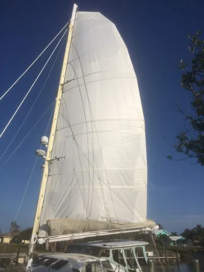 Vitesse Yacht Photos Pics Lagoon 55 sailboat from 1989 with fully raised sail against a clear blue sky.
