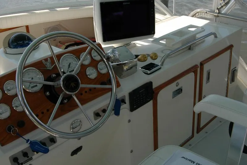 Vesper Yacht Photos Pics 1987 Bertram 33 Sport Fisherman helm with steering wheel and navigation instruments.