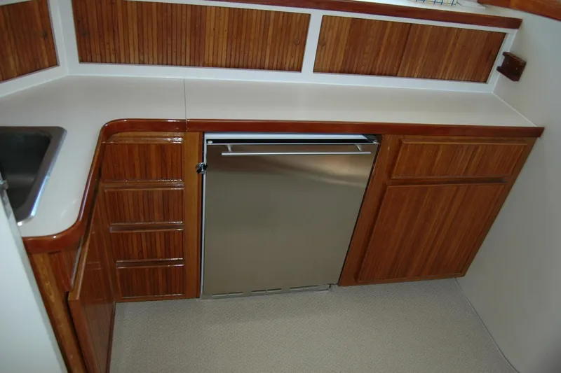 Vesper Yacht Photos Pics 1987 Bertram 33 Sport Fisherman galley with wood cabinetry and stainless steel appliances.